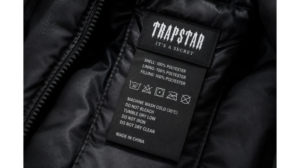Zbliżenie na metkę kurtki Trapstar z symbolami prania